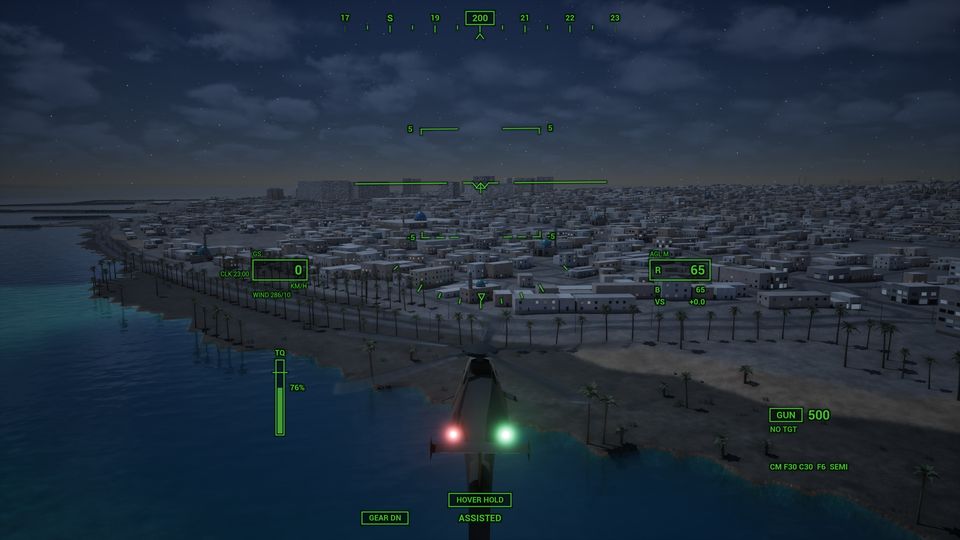 Night flight over a coastal town with lit streets, the aircraft's navigation lights showing red and green